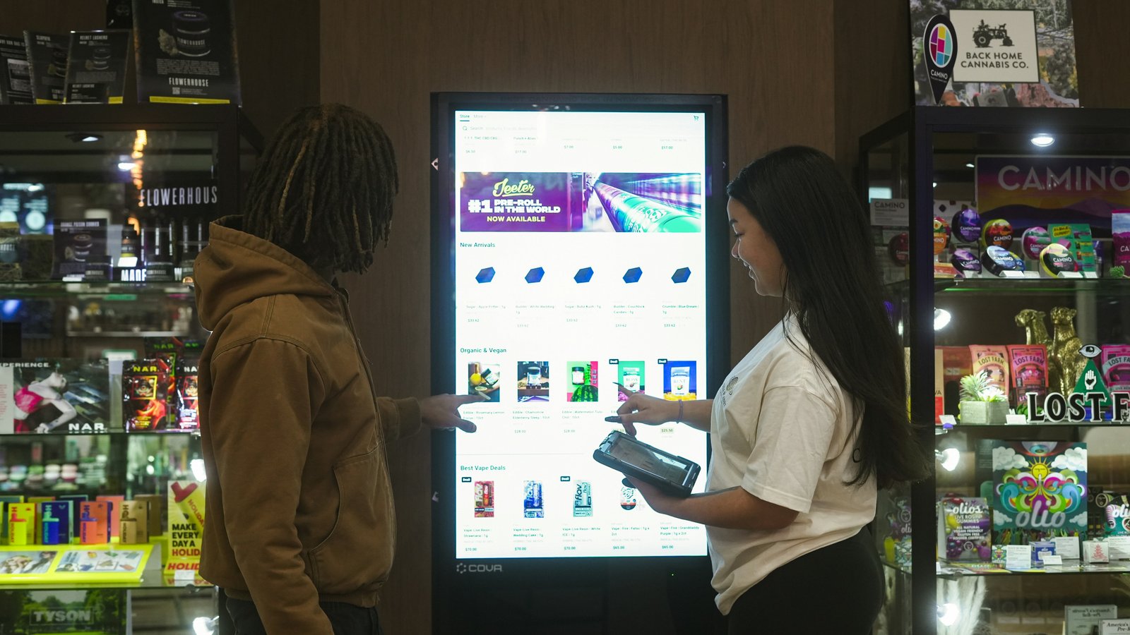 Two people reviewing a digital retail experience on an interactive screen.